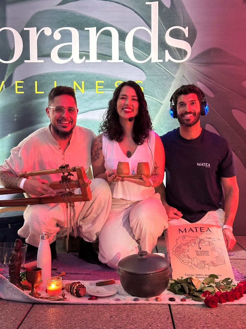 Melina Dau com colaboradores no evento Brands Wellness segurando o cacau
