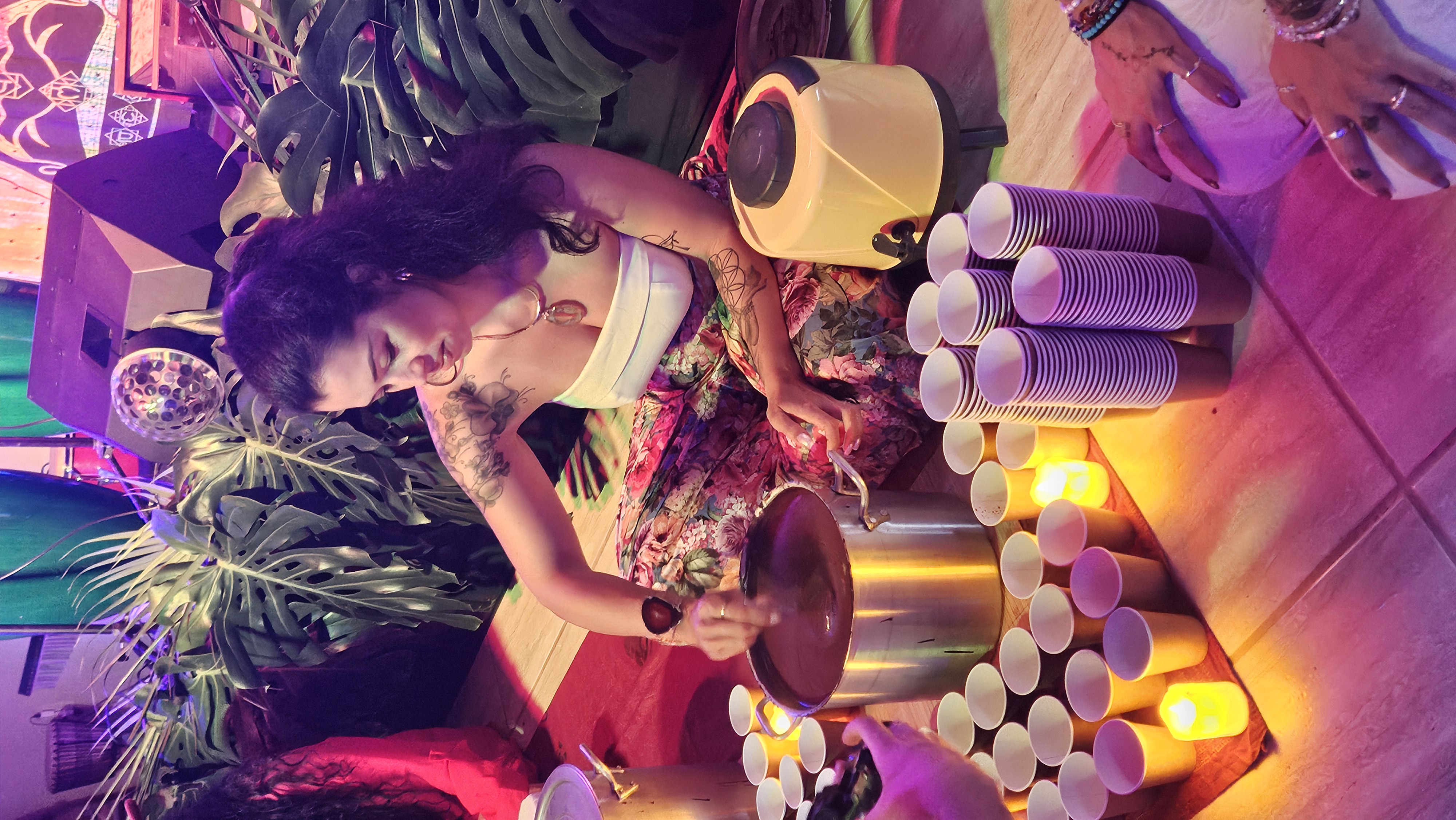 Melina Dau preparando o cacau em panela com velas ao redor